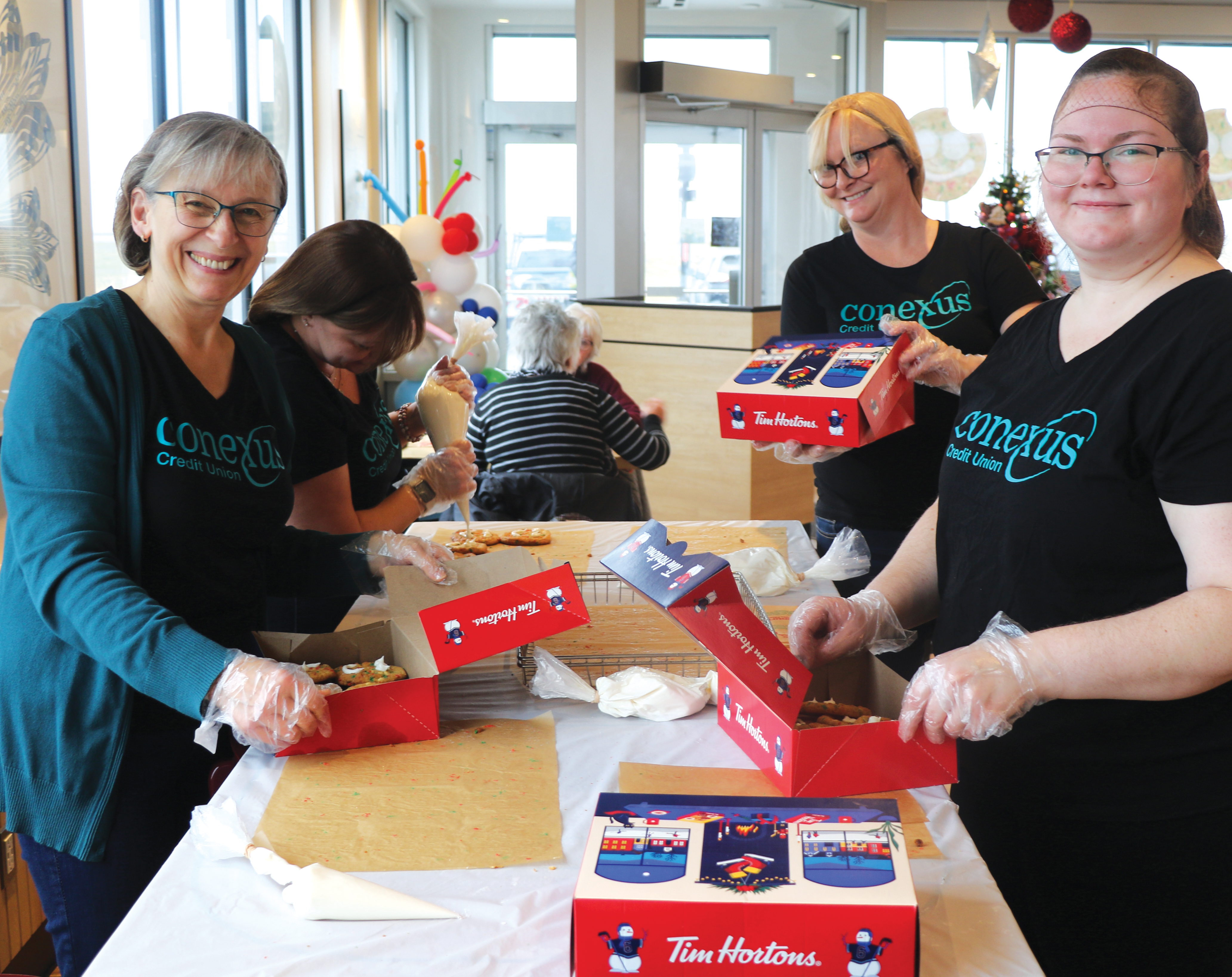 Volunteers with Conexus decorating Holiday Smile Cookies last week.